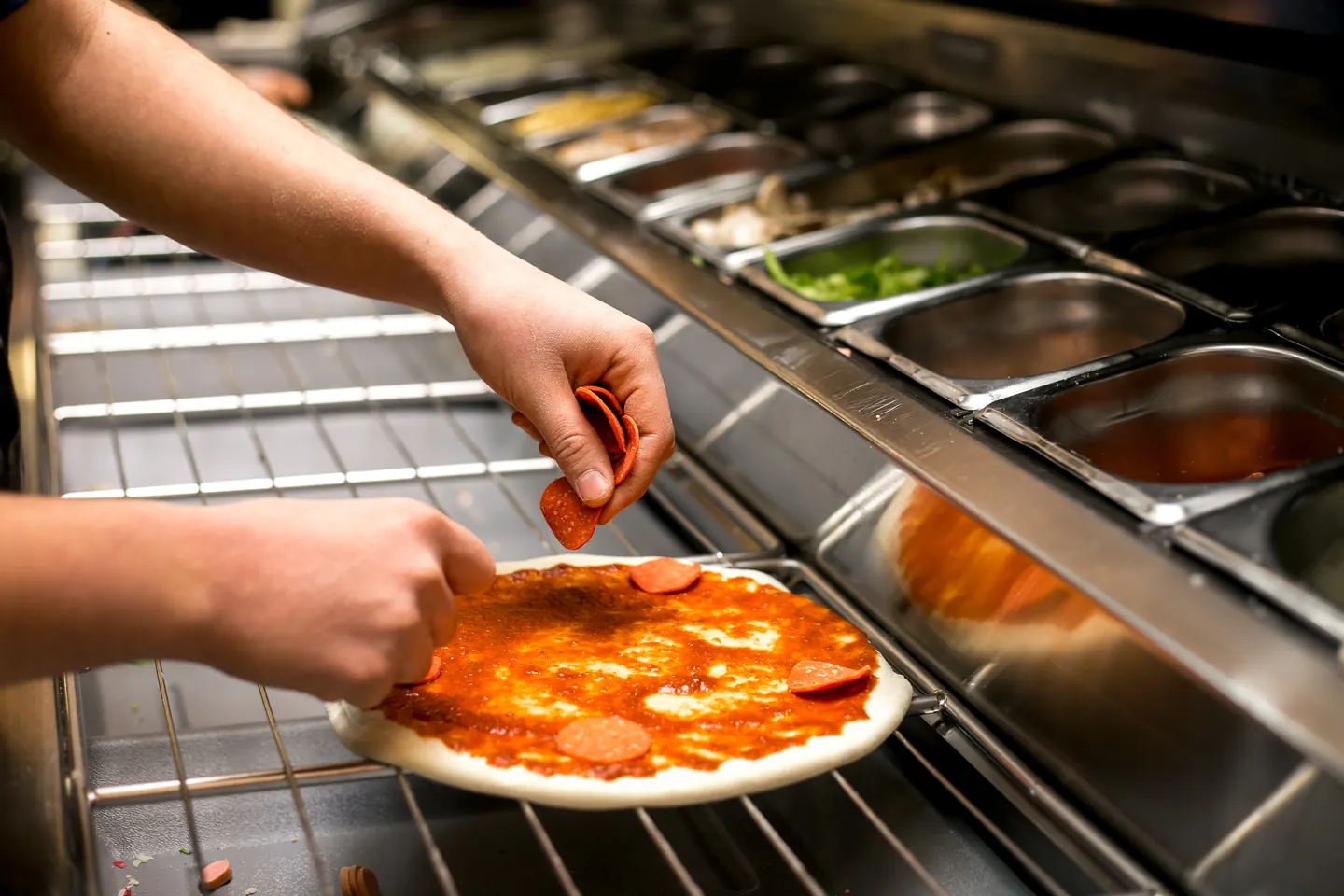 Pizza wird frisch belegt